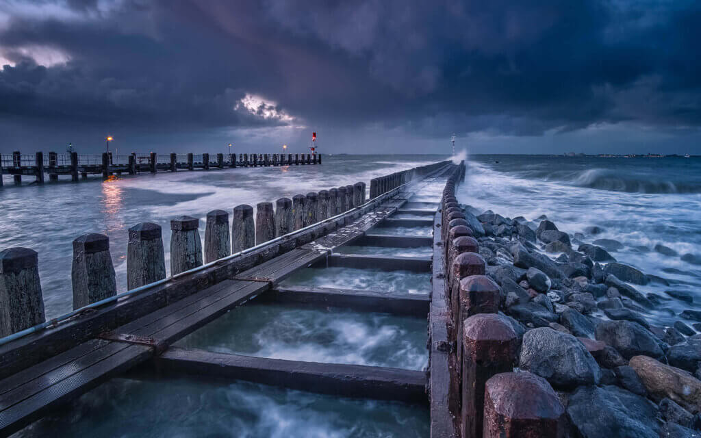 Storm bij de haven pier, met inkomende dreigende lucht en golven, van Vlissingen.