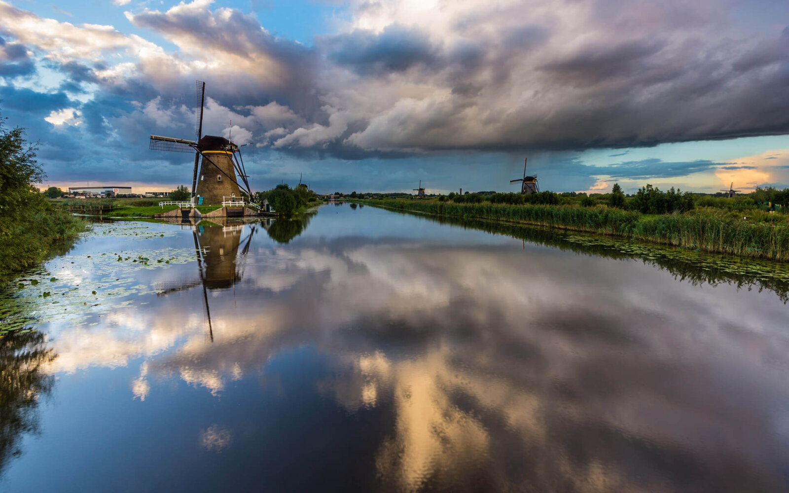 Kinderdijk Zware regenwolken drijven over de Kinderdijkse molens heen.