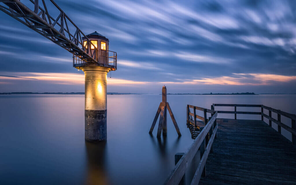 Bij de peilschaal van Oostmahorn, net voor zonsopkomst, aan het Lauwersmeer.