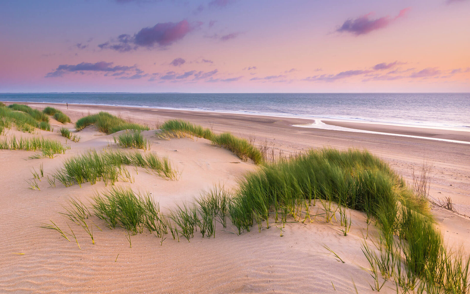 Ouddorp Serene en prachtige zonsondergang bij de duinen, met helmgras, en het strand bij Ouddorp.