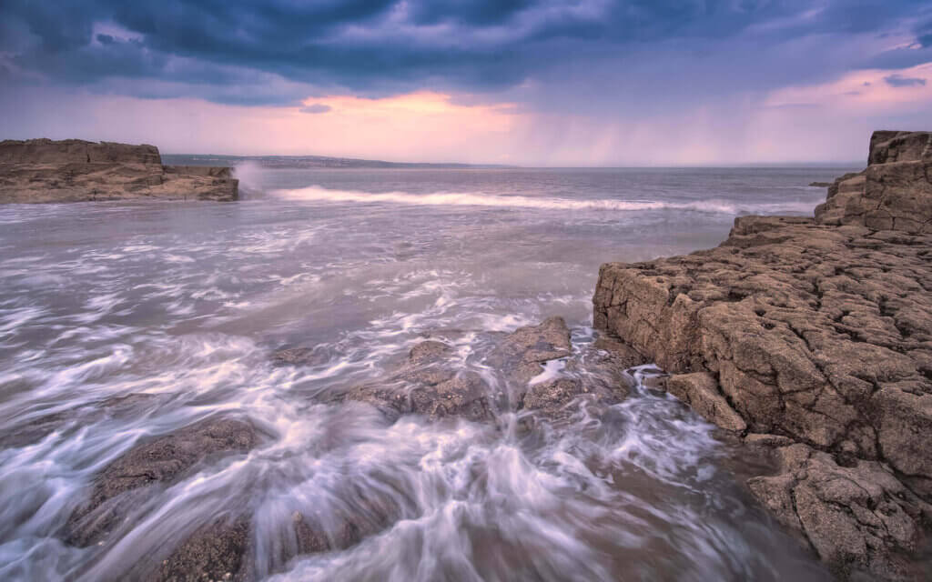 Grote regenbui boven de zee bij de kust van Porthcawl.