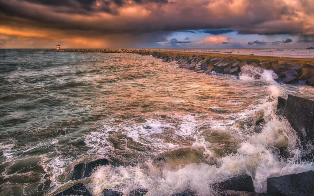 Brekende golven tegen de basaltblokken in de haven, tegen de pier, tijdens een storm bij Scheveningen.