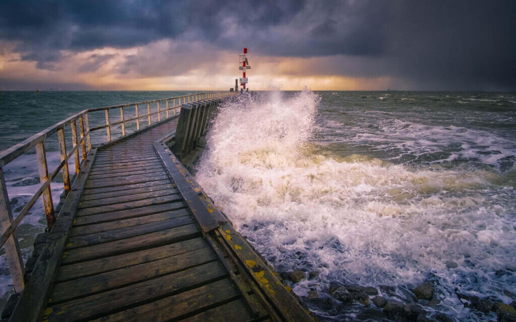 Brekende golf op een steiger, tijdens een storm bij Vlissingen.