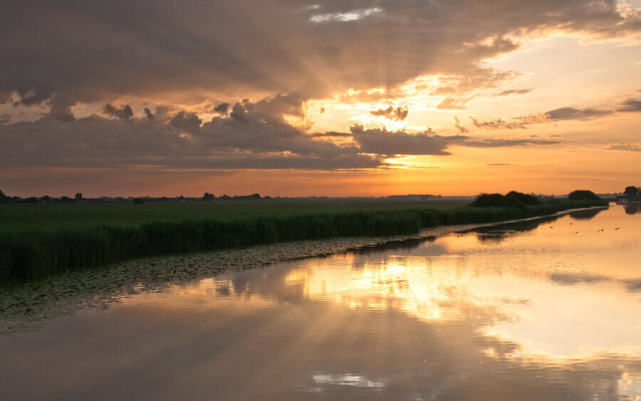 Prachtige zonneharp weerspiegeld in de rivier bij het gehucht De Donk.