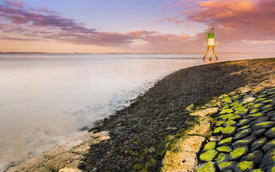 Een baken in de Westerschelde met het laatste avondlicht, in de buurt van Walsoorden.