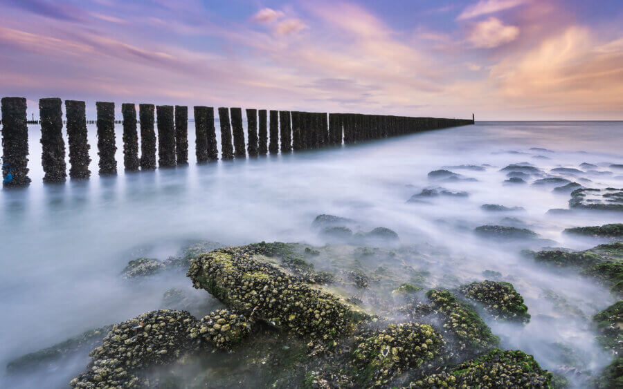 Langzaam zakt de zon onder bij de Noordzee, dichtbij Westkapelle.