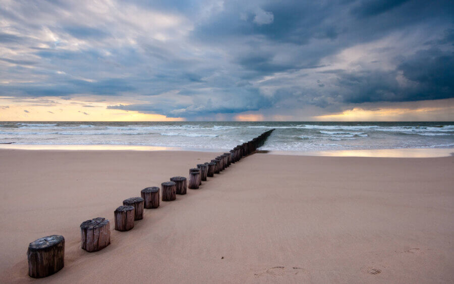Een regenbui is vanaf de Noordzee onderweg naar het strand van Burgh-Haamstede.