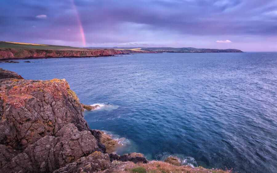 Een regenboog met een dreigende lucht boven de kustlijn van Eyemouth.