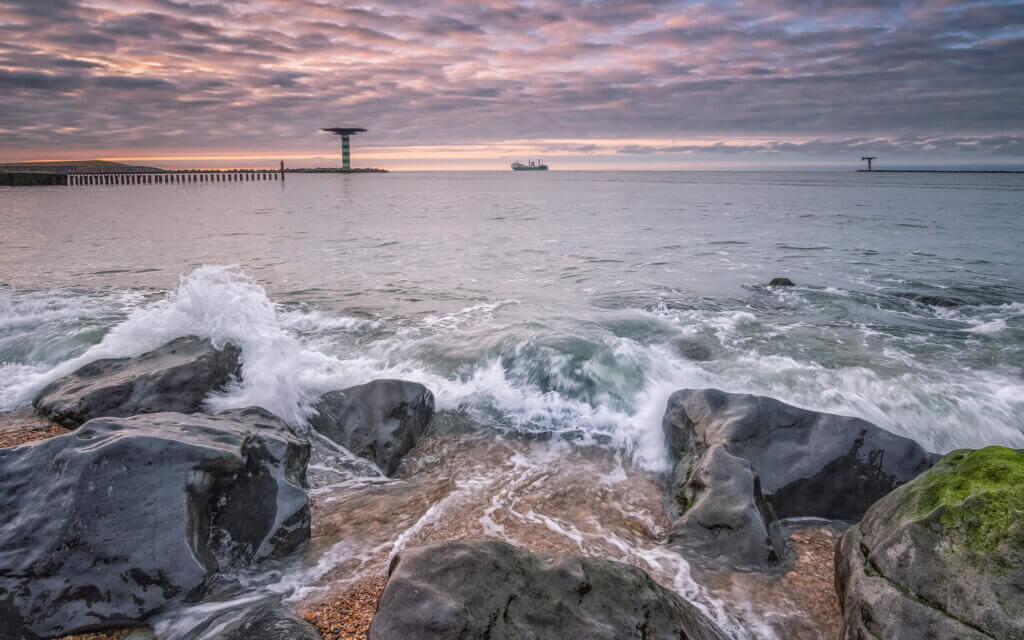 Een schip verlaat de veilige haven van de Maasvlakte, bij Rotterdam, de Noordzee op.