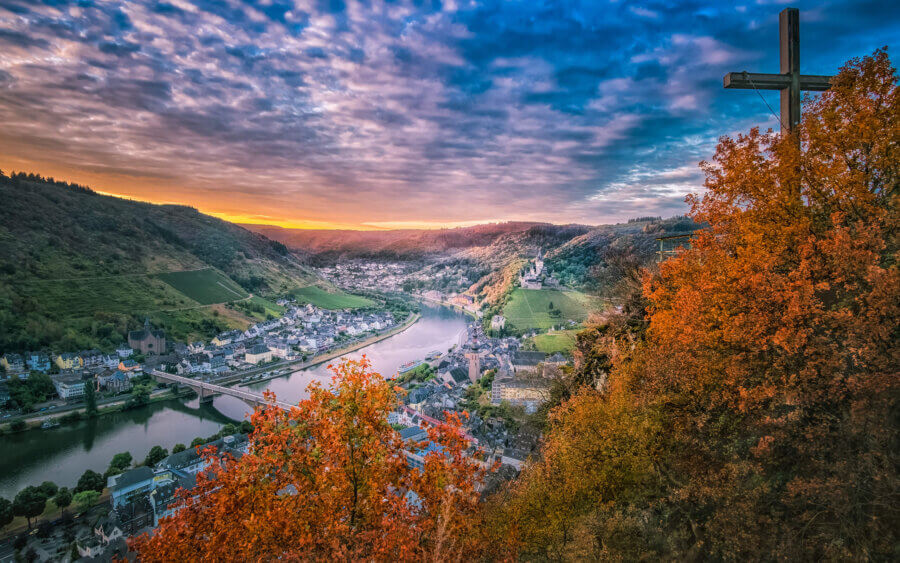 Cochem Op een vroege ochtend met zicht vanaf het observatieplatform Pinnerkreuz op de stad Cochem. We zien de Burg Cochem, St. Martin kerk, Skagerak-Brücke en de rivier de Moezel met zonsopkomst.