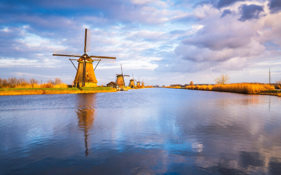 Kinderdijk De beroemde molens van Kinderdijk tijdens het begin van een prachtige avond in de Alblasserwaard. Prachtige weerspiegeling van de lucht en molen in het water.