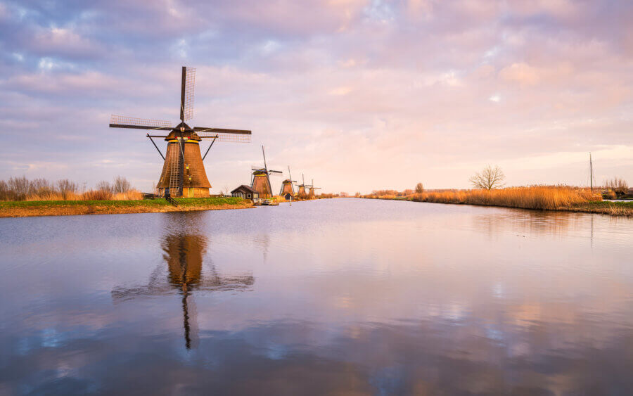 Kinderdijk Prachtige, vredige en kalme lentezonsondergang bij de windmolens van Kinderdijk. Mooie weerspiegeling van de windmolen en de wolken in de beek.