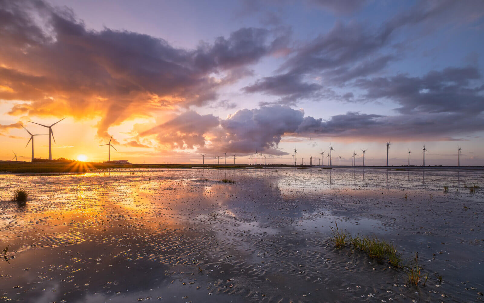 Bruinisse De zon schijnt, net na zonsopkomst, het felle licht op de wolken die over de Oosterschelde drijven.